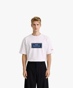 Vue de face d’un homme portant un t-shirt oversize blanc Salut Fred avec motif Rue de la Paix de la collection Rues de France