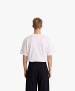 Vue de dos d’un homme portant un t-shirt oversize blanc Salut Fred avec motif Rue de la Paix de la collection Rues de France