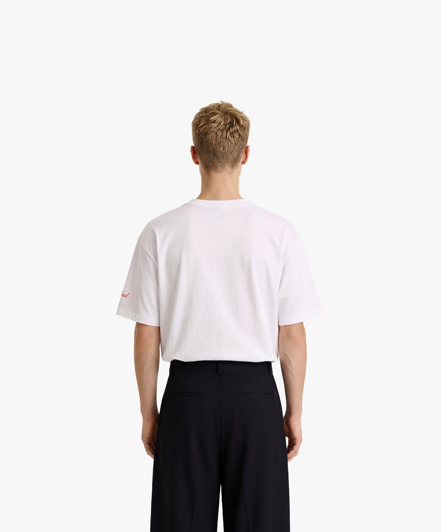 Vue de dos d’un homme portant un t-shirt oversize blanc Salut Fred avec motif Rue de la Paix de la collection Rues de France