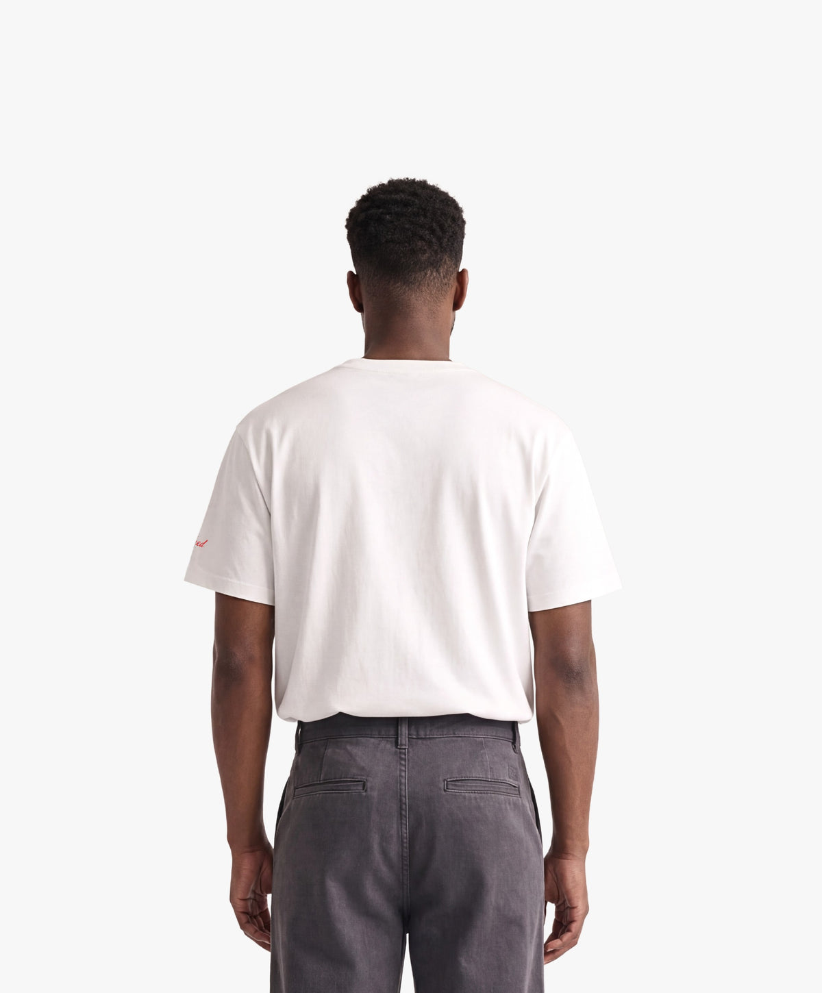 Vue de dos d’un homme portant un t-shirt oversize blanc Salut Fred avec motif Rue Duquesne de la collection Rues de France