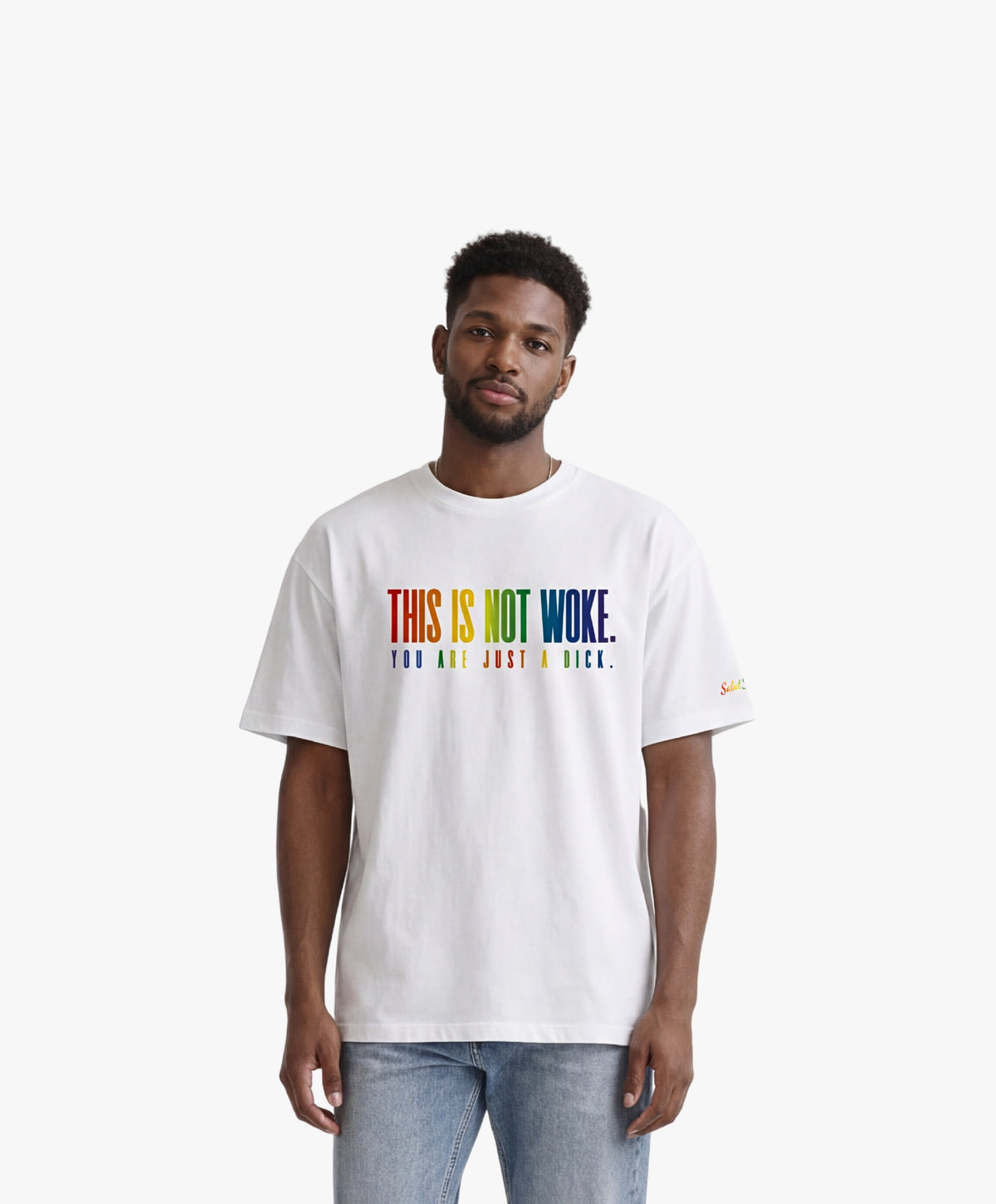 Vue de face d’un homme portant un t-shirt oversize blanc Salut Fred de la collection « This is not woke. You are just a dick. » avec slogan multicolore imprimé au centre de la poitrine et logo Salut Fred arc-en-ciel sur la manche gauche