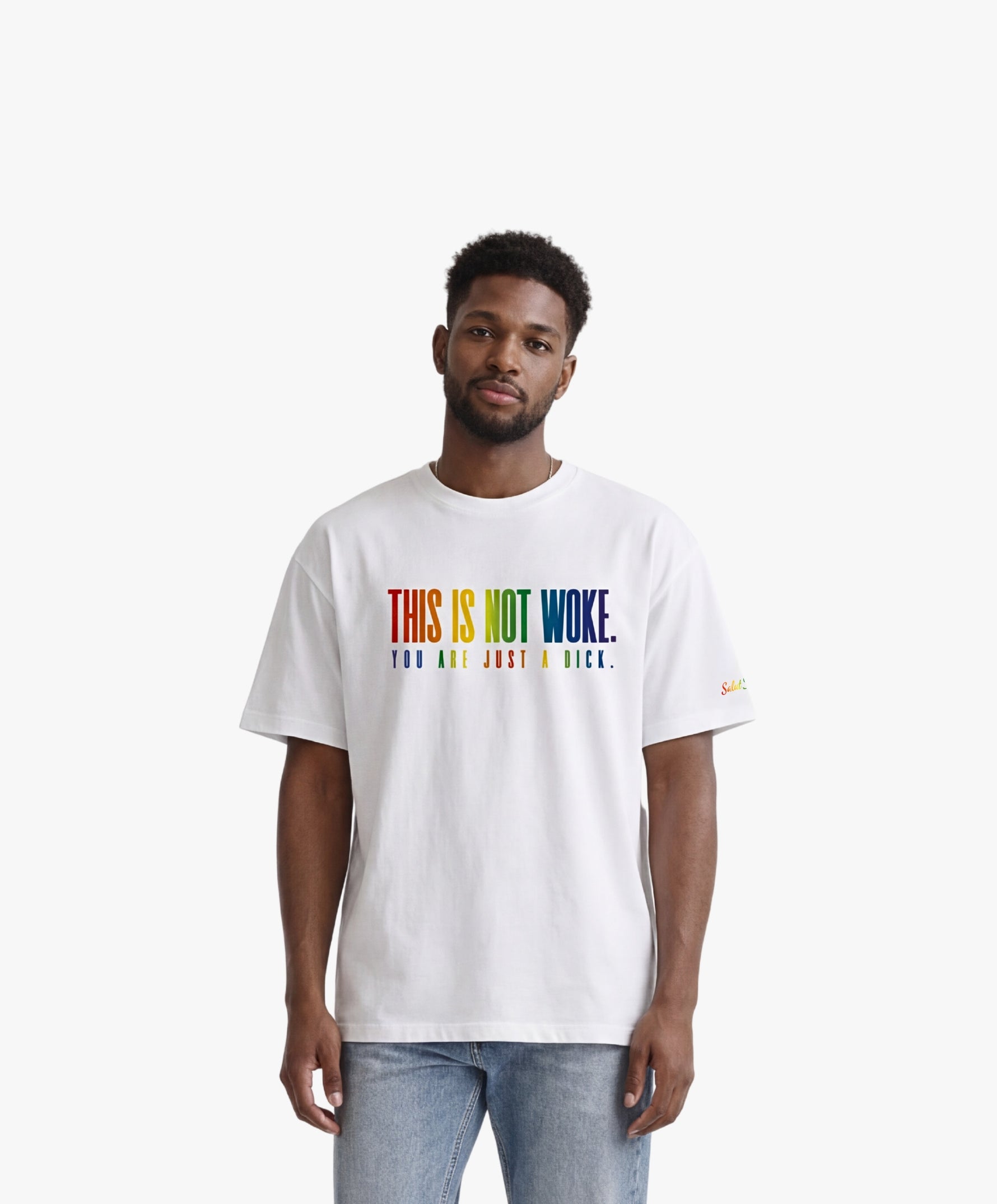Vue de face d’un homme portant un t-shirt oversize blanc Salut Fred de la collection « This is not woke. You are just a dick. » avec slogan multicolore imprimé au centre de la poitrine et logo Salut Fred arc-en-ciel sur la manche gauche