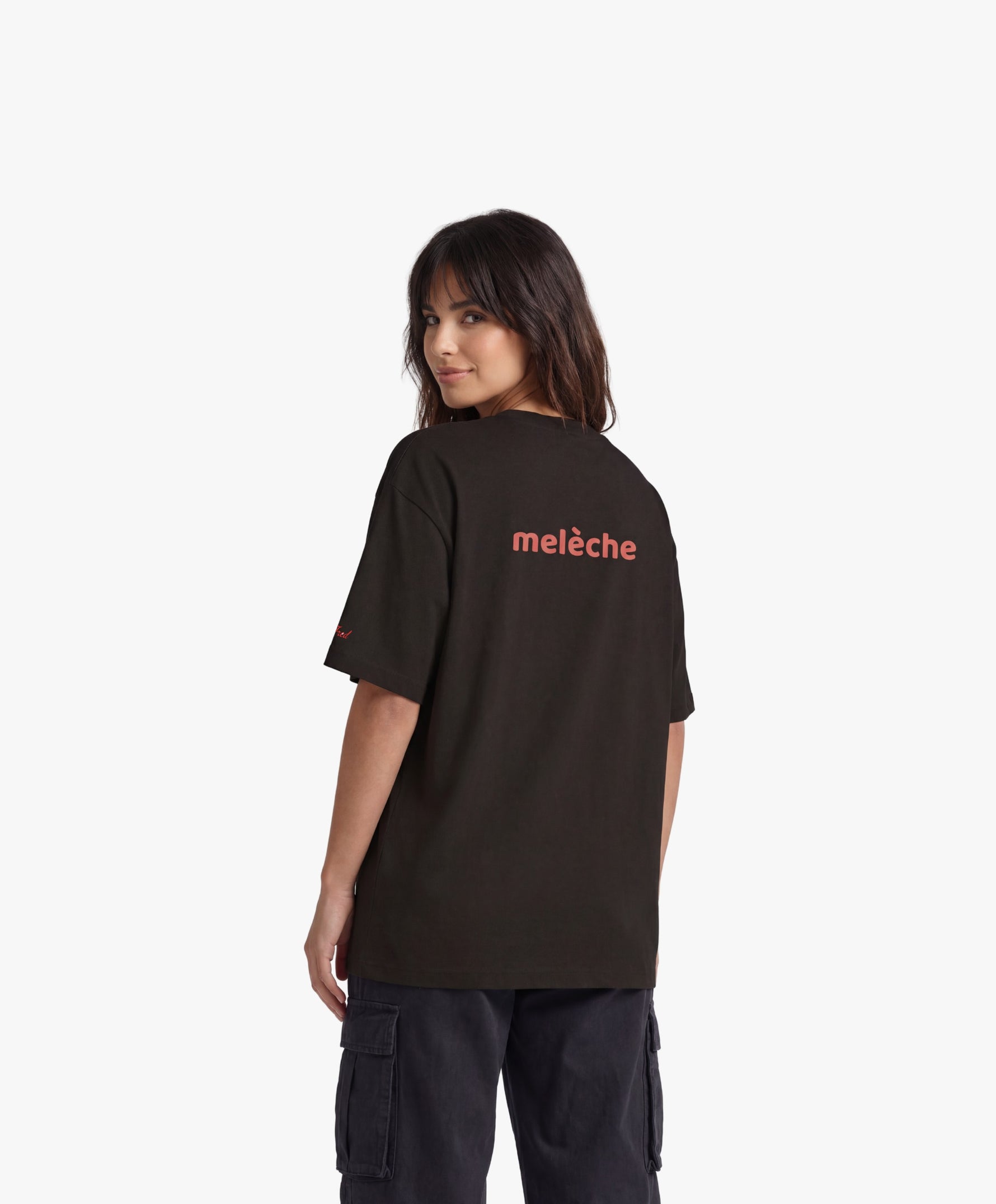 Femme vue de dos portant le t-shirt oversize noir « Melon Melèche » avec texte imprimé « melèche » centré dans le dos.