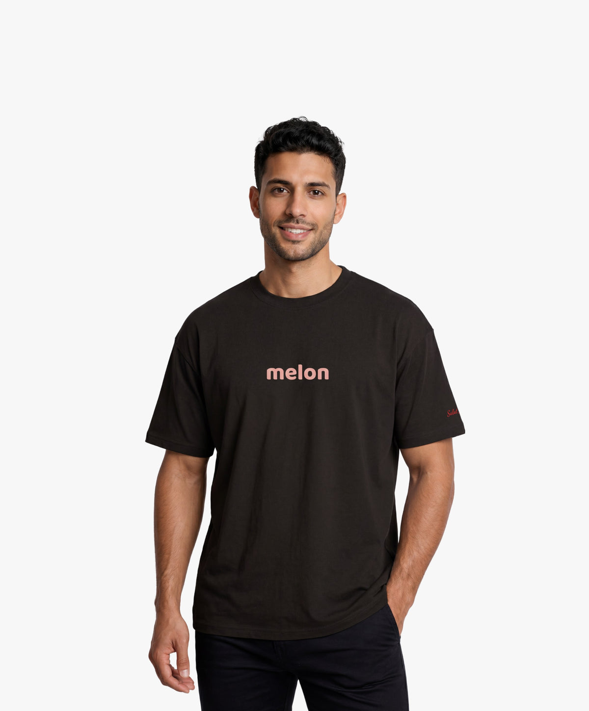 Homme vue de face portant le t-shirt oversize noir « Melon Melèche » avec texte imprimé « melon » centré sur la poitrine et logo Salut Fred sur la manche gauche.