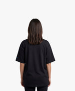 Vue de dos d’une femme portant un t-shirt oversize noir Salut Fred