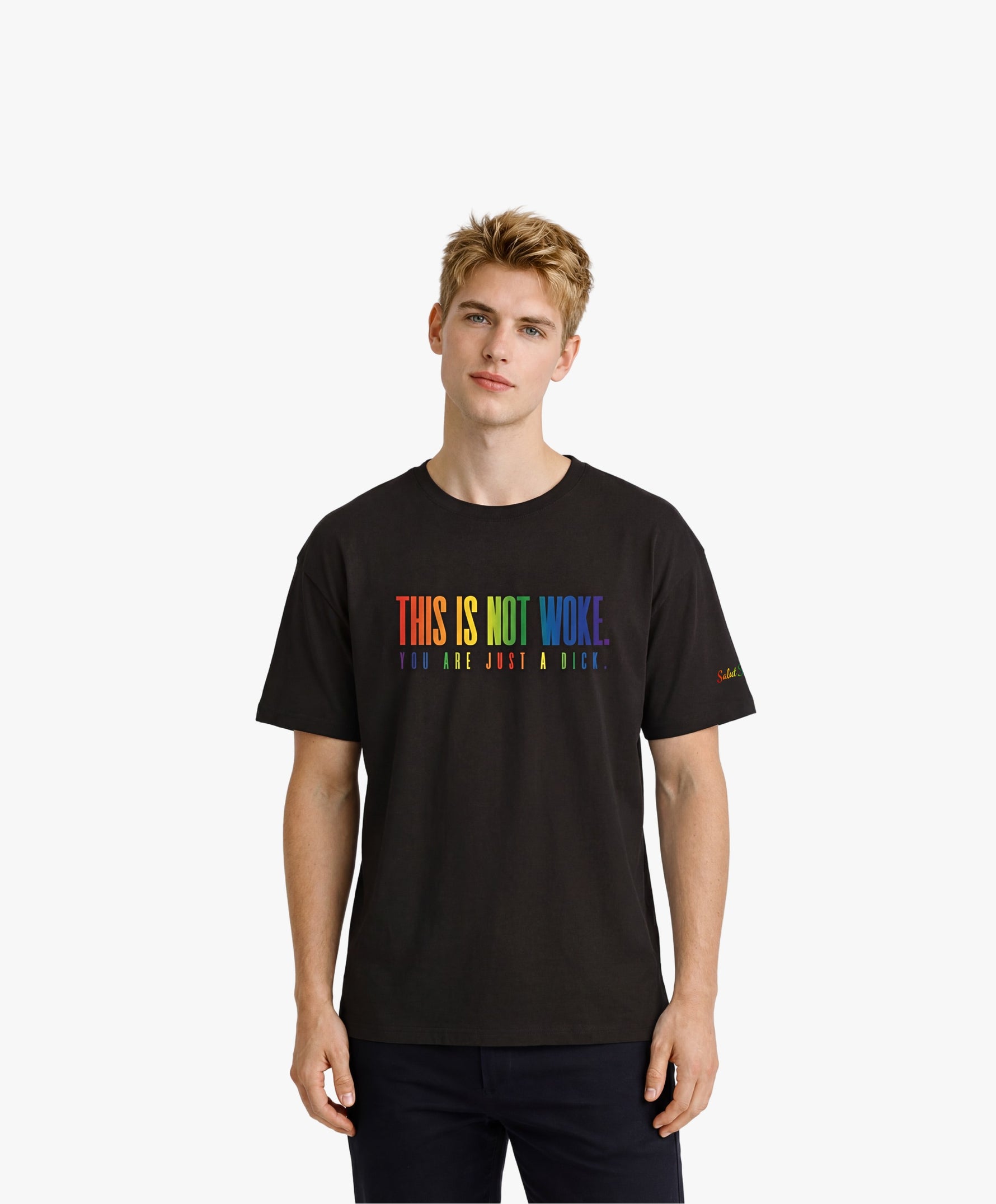 Vue de face d’un homme portant un t-shirt oversize noir Salut Fred de la collection « This is not woke. You are just a dick. » avec slogan multicolore imprimé au centre de la poitrine et logo Salut Fred arc-en-ciel sur la manche gauche